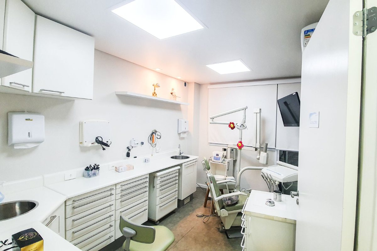 Sala de atendimento da Farac Odontologia, branca, com cadeira odontológica verde-clara